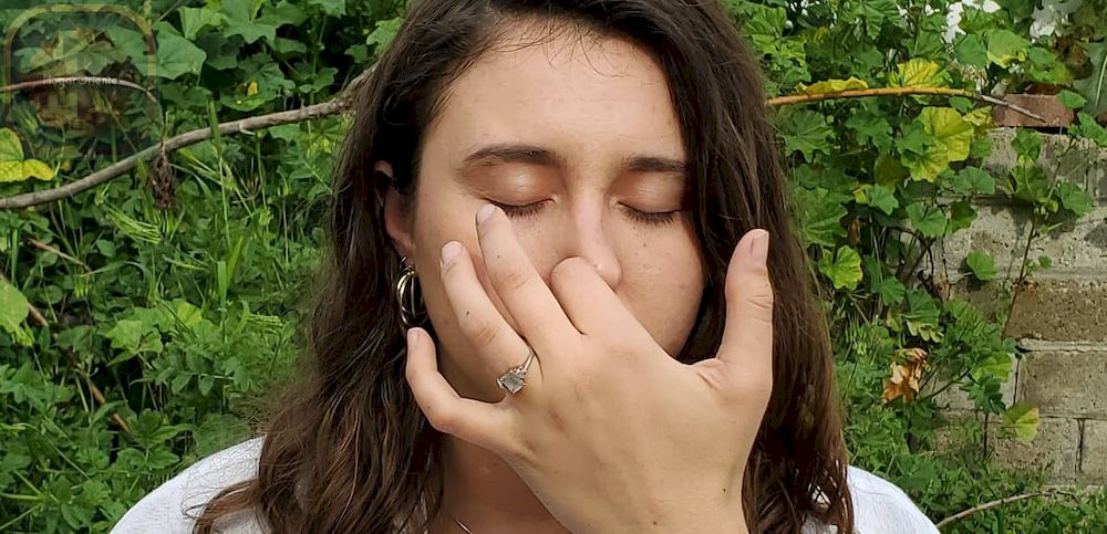 mujer tapándose la nariz mientras practica nadi shodhan