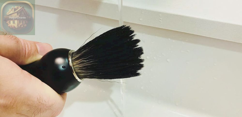 enjuagar el cepillo de barba en el lavabo del baño