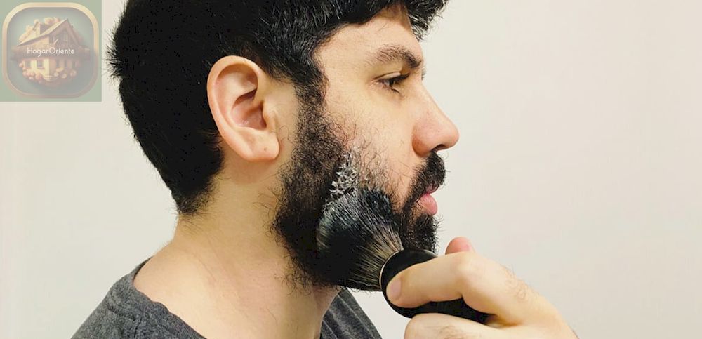 hombre aplicando crema de afeitar a la barba con un cepillo para barba