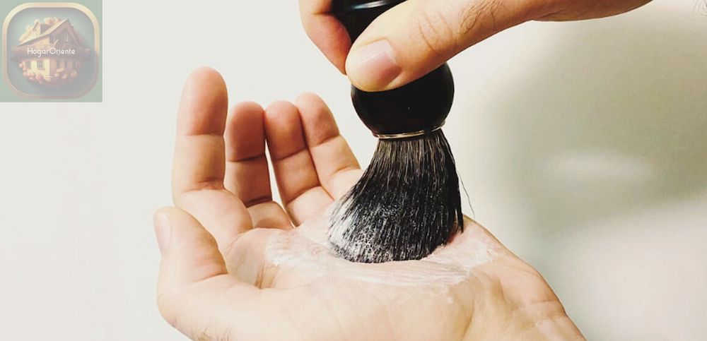 cepillo de barba enjabonado con crema de afeitar en la palma de la mano
