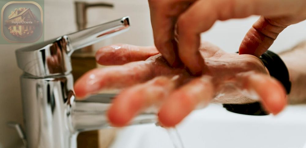 lavarse las manos con jabón en un fregadero de cocina