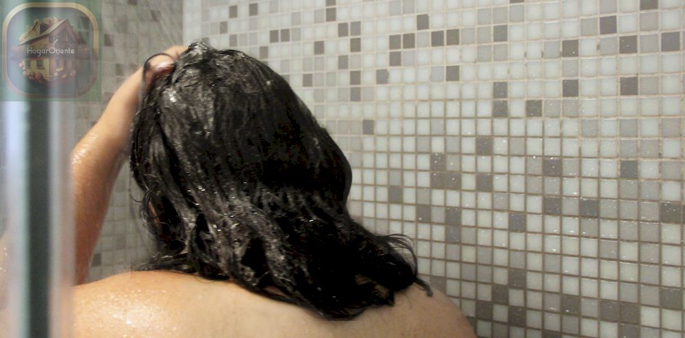 mujer masajeando espuma en el cuero cabelludo