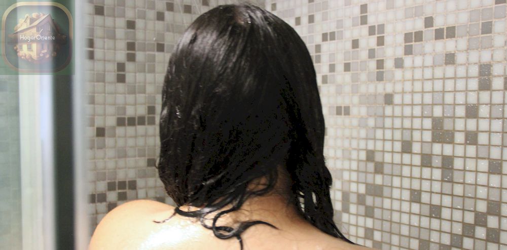 mujer enjuagándose el pelo en la ducha