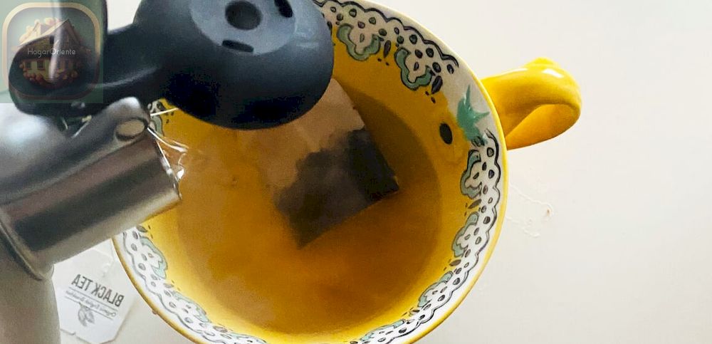 verter agua caliente de la tetera en la taza de té
