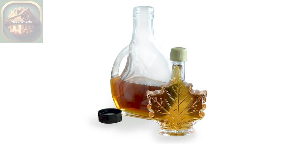 botella de jarabe de arce en un recipiente de hojas de arce y una botella de jarabe de arce en un recipiente redondo