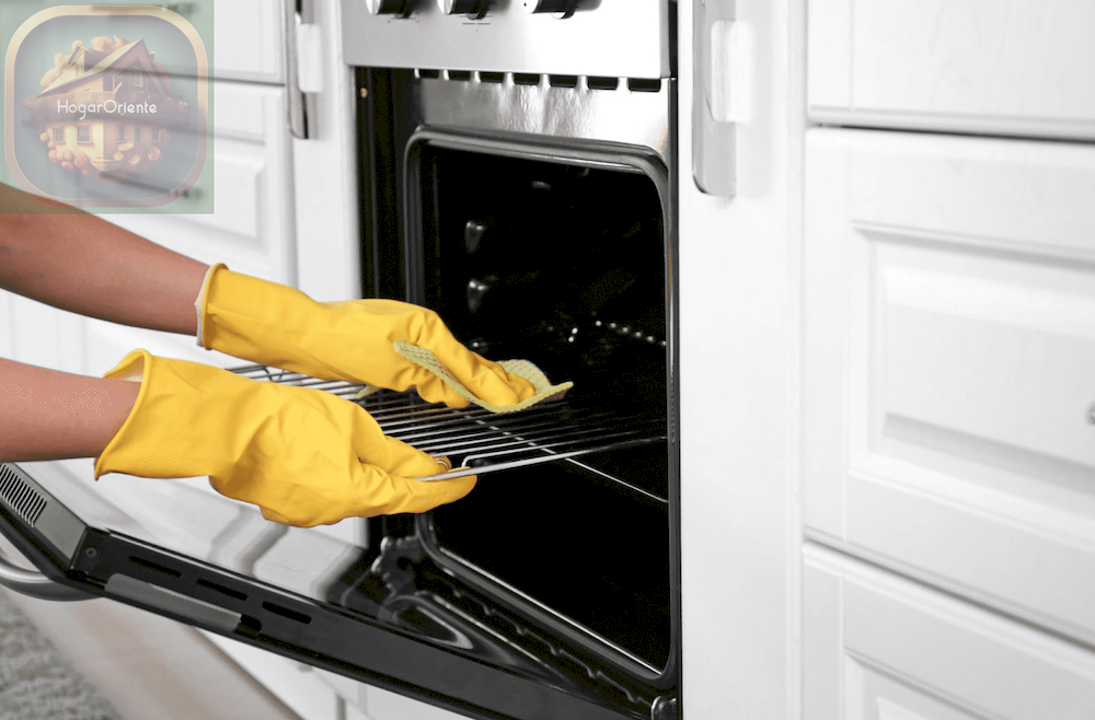 Imagen de persona limpiando un horno con guantes de goma