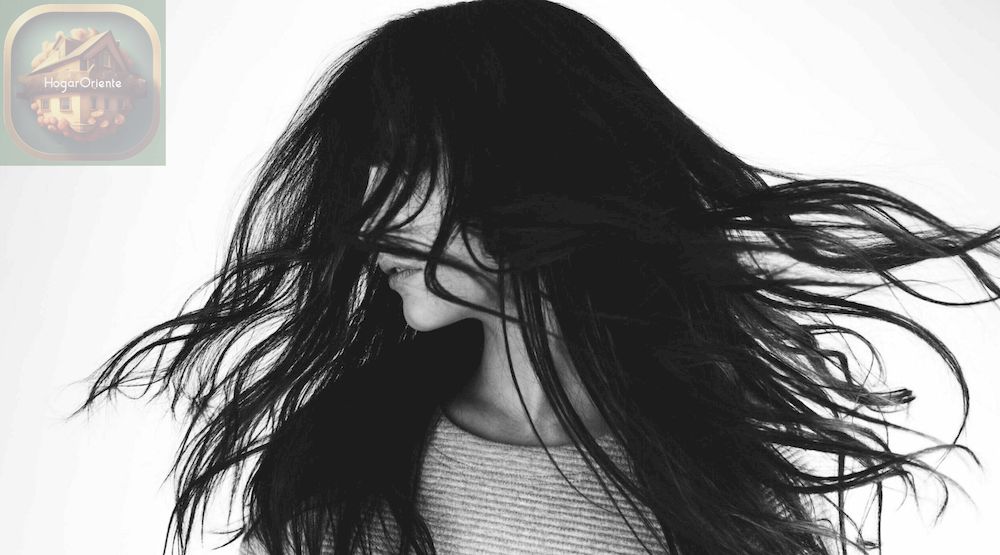 foto en blanco y negro de una mujer balanceando su cabello negro de un lado a otro